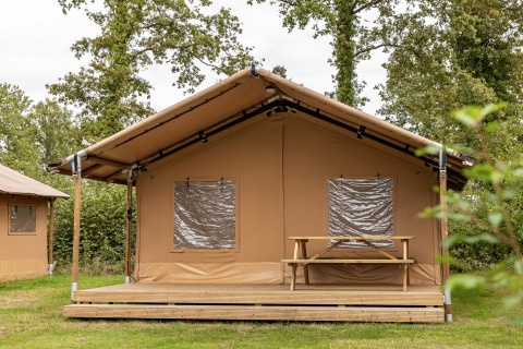 Safari tent at Holiday Park Hunzedal 15 in the Netherlands, with wooden deck and picnic table outside.