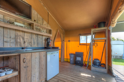 Interior of a safari tent at Holiday park Hunzedal 15, Netherlands, featuring a rustic wooden kitchen.
