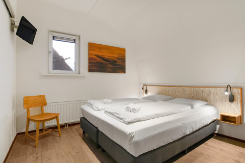 Modernes Zimmer in der Water park De Bloemert 7 Lodge in den Niederlanden mit Doppelbett und TV.
