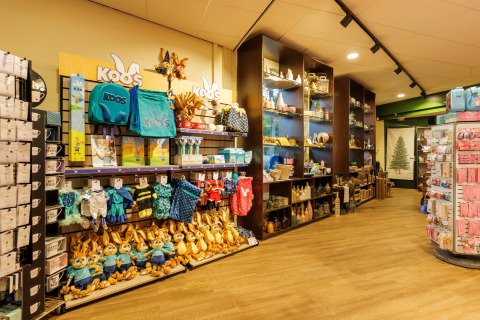 Interieur van een safaritentwinkel met rekken vol knuffeldieren, speelgoed en diverse souvenirs.