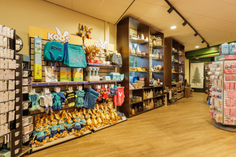 Indretning af en butik med produkter og udstoppede dyr i en safariteltscamp, med hylder og legetøj.