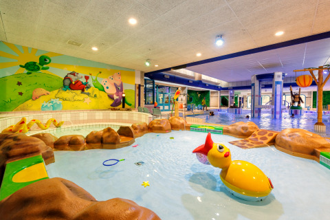 Overdekt kinderbad met vrolijke dierenfiguren en kleurrijke muurschildering, perfect voor spelende kids.