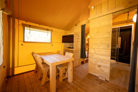 Interieur van de safaritent in Holiday park ‘Hunzedal 16’ met eethoek, keuken en badkamer.