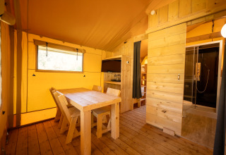 Interieur van de safaritent in Holiday park ‘Hunzedal 16’ met eethoek, keuken en badkamer.