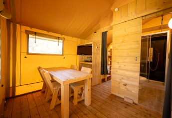 Interieur van de safaritent in Holiday park ‘Hunzedal 16’ met eethoek, keuken en badkamer.