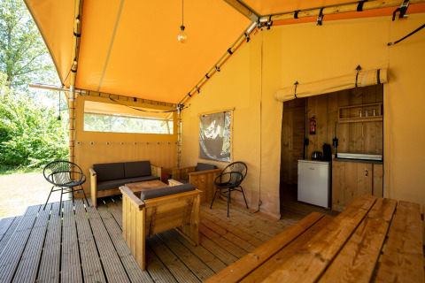 Safari telt ved Holiday park Hunzedal 16 i Holland, med træmøbler og udendørs siddeområde.