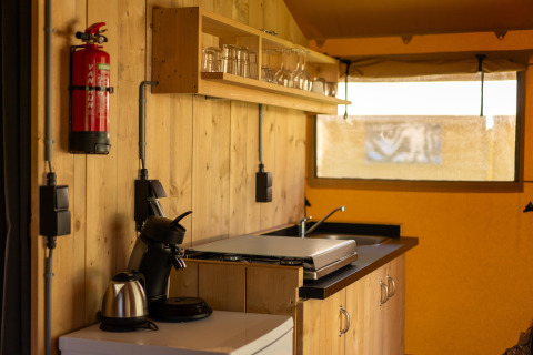 Intérieur de la tente safari Holiday park ‘Hunzedal 16’ aux Pays-Bas, montrant une kitchenette.