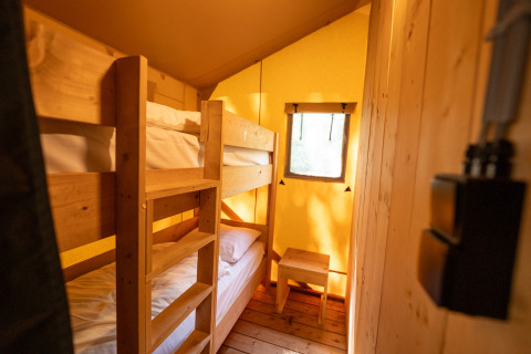 Interior of a safari tent bedroom with wooden bunk beds at Holiday park Hunzedal 16 in Netherlands.