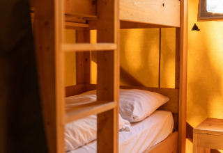 Cozy room with wooden bunk bed inside a safari tent at Holiday park Hunzedal 16 in the Netherlands.