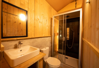 Badeværelse i safari telt ved Holiday park «Hunzedal 16» i Holland med trævægge og moderne brusekabine.