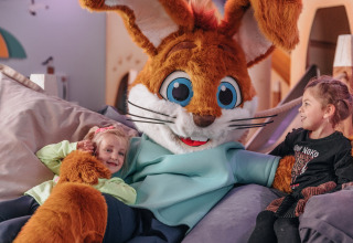 Børn hygger sig med stor kaninmaskot i safaritelten Holiday park «Hunzedal 16» i Holland.