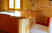Cucina in legno con bancone e sedia bianca e rossa presso Holiday homes Quinta dos Curubás in Portogallo.