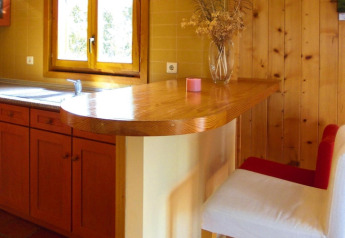 Cucina in legno con bancone e sedia bianca e rossa presso Holiday homes Quinta dos Curubás in Portogallo.