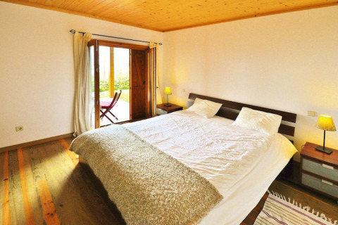 Slaapkamer in Holiday Homes Quinta dos Curubás, Portugal, met tweepersoonsbed, hout en balkon.