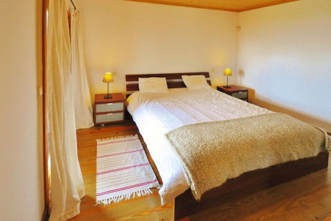Lichte slaapkamer met tweepersoonsbed, nachtkastjes, lampen en houten vloer in Quinta dos Curubás, Portugal.