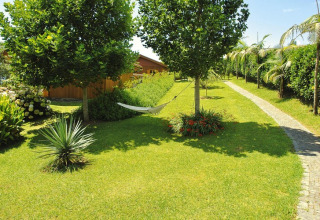 Verzorgde tuin met een hangmat tussen bomen bij Holiday homes Quinta dos Curubás in Vila Franca do Campo, Portugal.