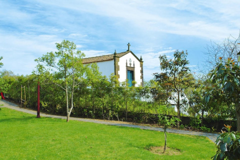 Groene tuin met kleine kapel bij de Quinta dos Curubás vakantiewoningen in Vila Franca do Campo, Portugal.