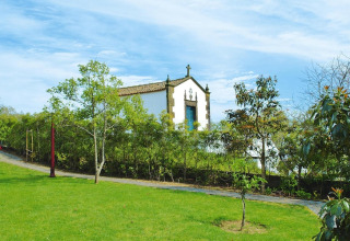 Groene tuin met kleine kapel bij de Quinta dos Curubás vakantiewoningen in Vila Franca do Campo, Portugal.