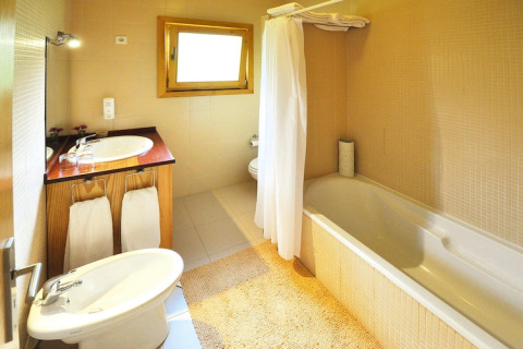 Lichte badkamer met bad, douche, wastafel en bidet in Holiday homes Quinta dos Curubás in Portugal.