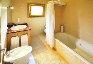 Lichte badkamer met bad, douche, wastafel en bidet in Holiday homes Quinta dos Curubás in Portugal.