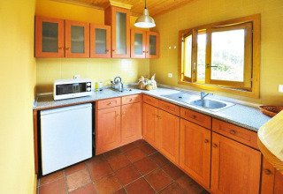 Lichte houten keuken met gele muren in Holiday homes Quinta dos Curubás, Vila Franca do Campo, Portugal.