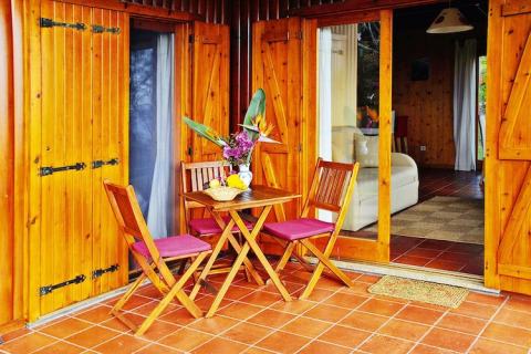 Houten terras met tafel en stoelen voor bungalow bij Quinta dos Curubás, Vila Franca do Campo, Portugal.