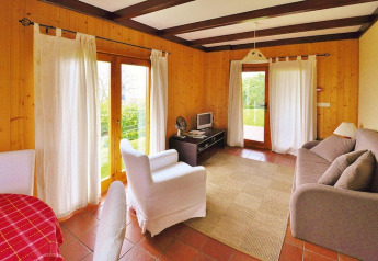 Luminoso soggiorno in un bungalow vacanze con pareti in legno, grandi finestre e arredi accoglienti in Portogallo.