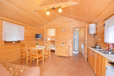 Sfeervol houten chalet met eetruimte, keuken en badkamer bij Cottages ranch by the sea in Denemarken.