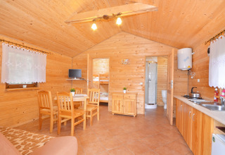 Interno di una cabina in legno con cucina, zona pranzo e bagno presso Cottages ranch by the sea, Danimarca.
