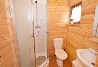Houten badkamer met douche, toilet en wastafel in de Cottages ranch by the sea in Denemarken.