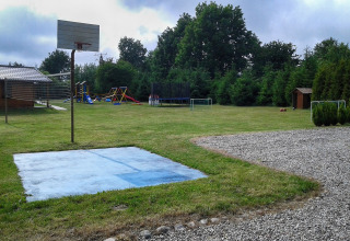 Udsigt over legeplads ved hytten 'Cottages ranch by the sea' i Danmark med basketballkurv og legeområde.