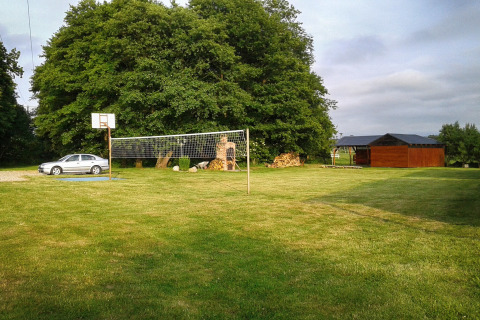 Sportterrein bij Cottages ranch by the sea in Denemarken met basketbalpaal, volleybalnet en grasveld.