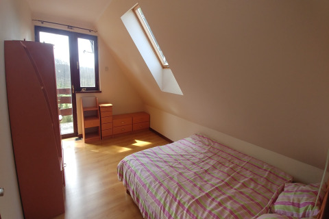 Chambre lumineuse à House Gajewo à Podlasie, Suède, avec lucarne, lit double et meubles en bois.