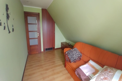 Chambre accueillante à House Gajewo à Podlasie, Suède, avec canapé orange et murs verts.