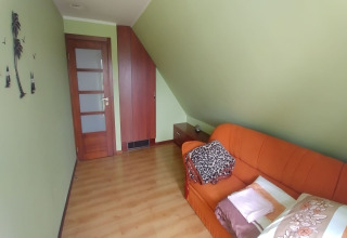 Chambre accueillante à House Gajewo à Podlasie, Suède, avec canapé orange et murs verts.