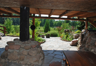Vue depuis une terrasse couverte avec pilier de pierre sur le jardin de la maison Gajewo à Podlasie, Suède.