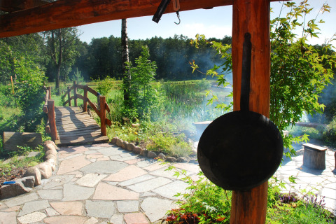 Vue depuis House Gajewo à Podlasie, Suède, avec sentier de pierre, pont en bois et poêle suspendue.