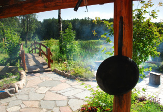 Vue depuis House Gajewo à Podlasie, Suède, avec sentier de pierre, pont en bois et poêle suspendue.