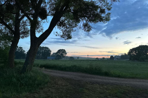 Photo de paysage à House Gajewo en Podlasie, Suède, avec champs, arbres et ciel de coucher de soleil paisible.