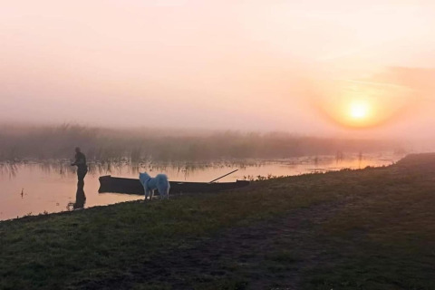 Lever du soleil paisible près de House Gajewo à Podlasie, Suède, avec un homme, un chien et une barque.