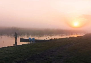 Lever du soleil paisible près de House Gajewo à Podlasie, Suède, avec un homme, un chien et une barque.