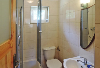 Kleines Badezimmer mit Dusche, WC, Waschbecken und Spiegel in einem Ferienhaus für 5 Personen in Wiselka, Deutschland.