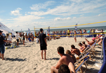 Strand-Volleyballspiel mit Zuschauern, Menschen entspannen an den Ferienhäusern in Kodrabek, Deutschland.