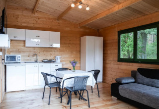 Gezellig natuurhuisje in Duitsland met houten interieur, keuken, eettafel, zetel en groot raam op de natuur.