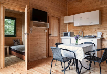 Casa vacanze Kodrabek-35 mq in Germania con interni in legno, cucina, tavolo da pranzo e camera da letto.
