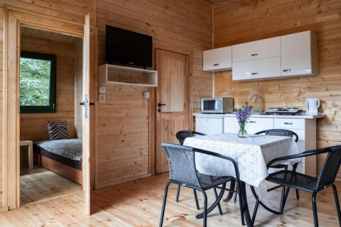 Maison de vacances à Kodrabek, Allemagne : intérieur bois, espace cuisine, salle à manger et chambre visible.