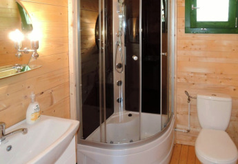 Bagno moderno con cabina doccia, toilette e lavabo in una casa vacanza di legno in Germania.