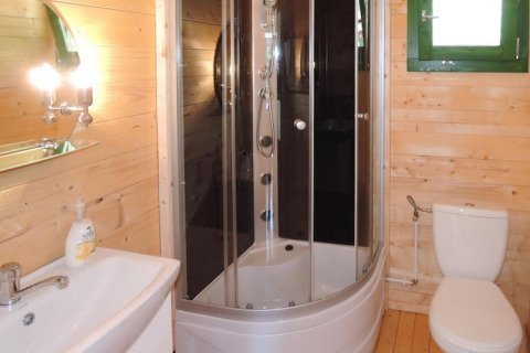 Modern bathroom with shower cabin, toilet, and sink in a wooden holiday home in Germany.