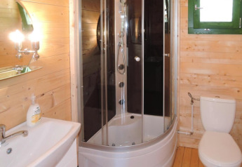 Salle de bains moderne avec douche, toilette et lavabo dans une maison de vacances en bois en Allemagne.