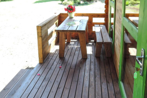 Udendørs veranda med træbord, bænk og blomsterkrukke ved Holiday homes, Kodrabek-35 kvm, Tyskland.